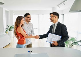 home buyers shaking hands with a realtor