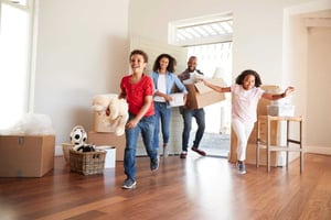Family carrying boxes into new home